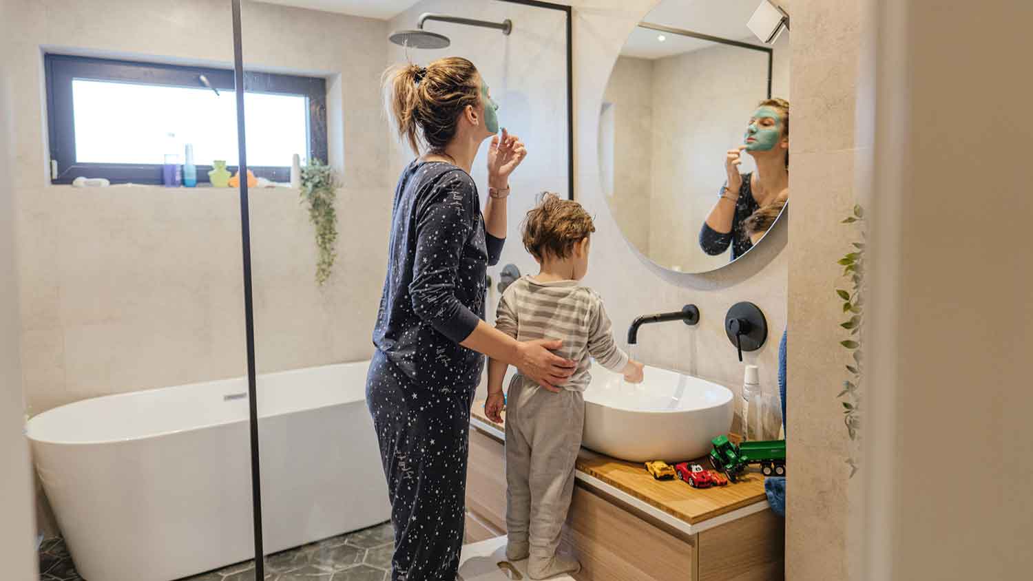 Mother looking in the mirror and son washing hands