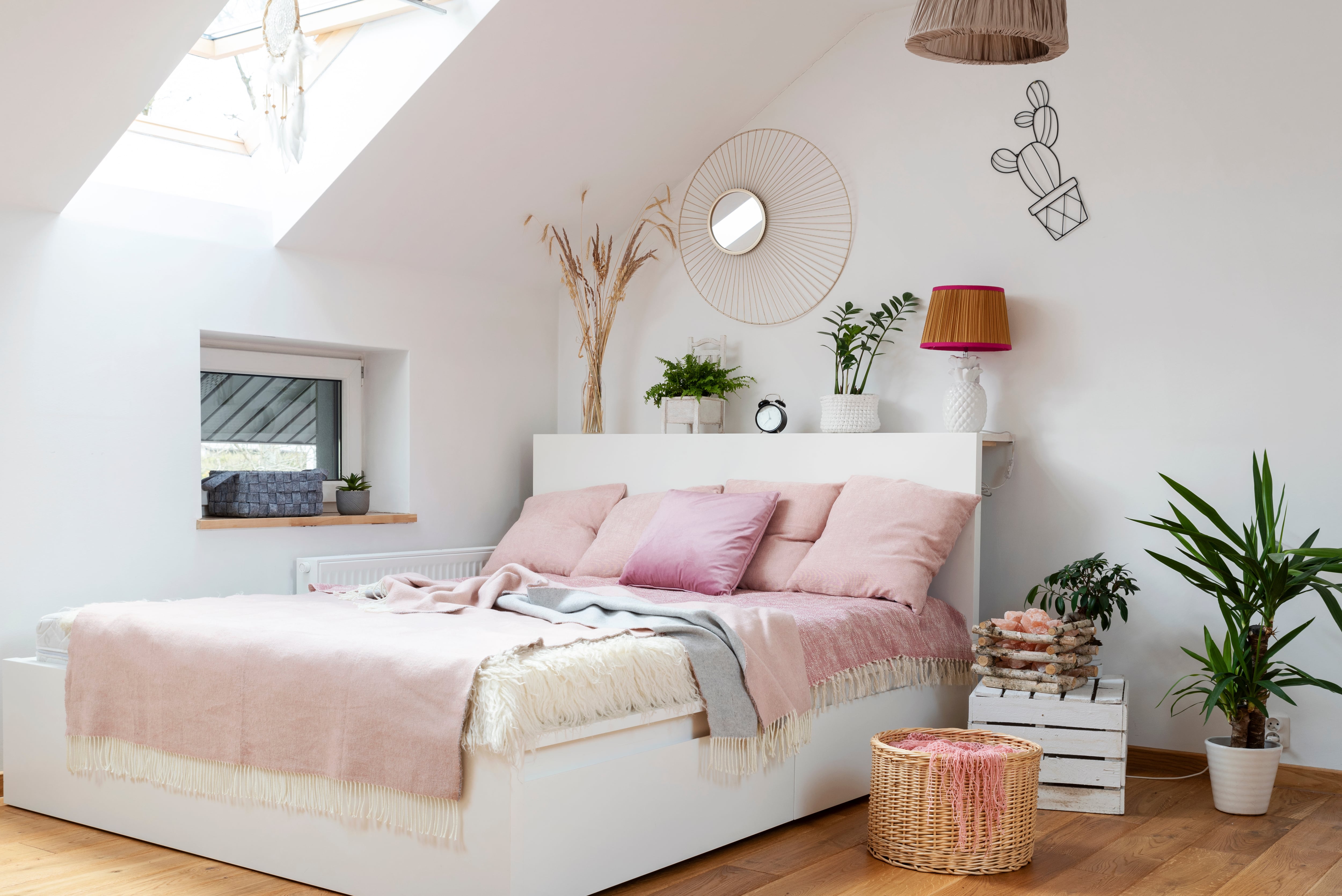 A pink-and-white bedroom in an attic interior with wood floors