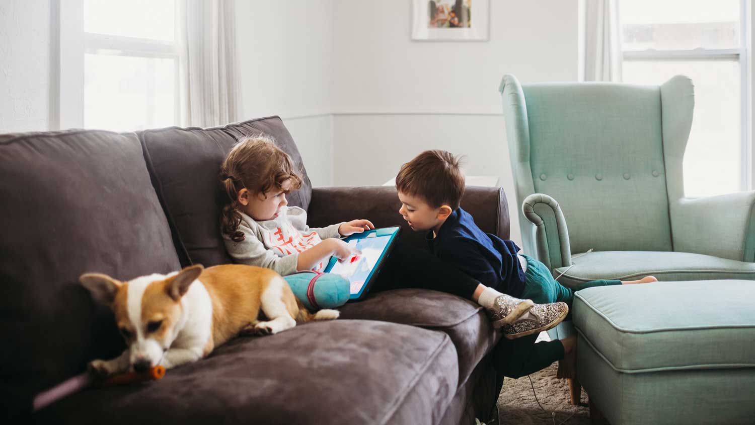 Siblings and pet sitting on the couch
