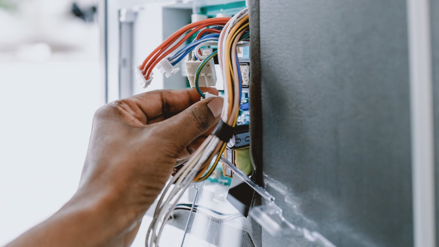 Woman Repairs Refrigerator's Core Circuit Board